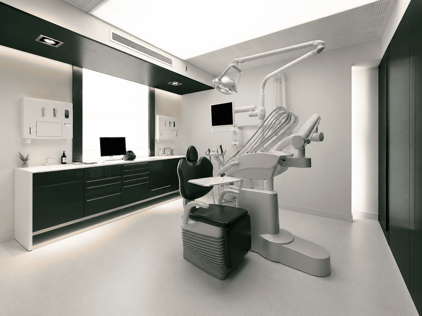 Salle de soins du cabinet, mobilier vert foncé et fauteuil dentaire