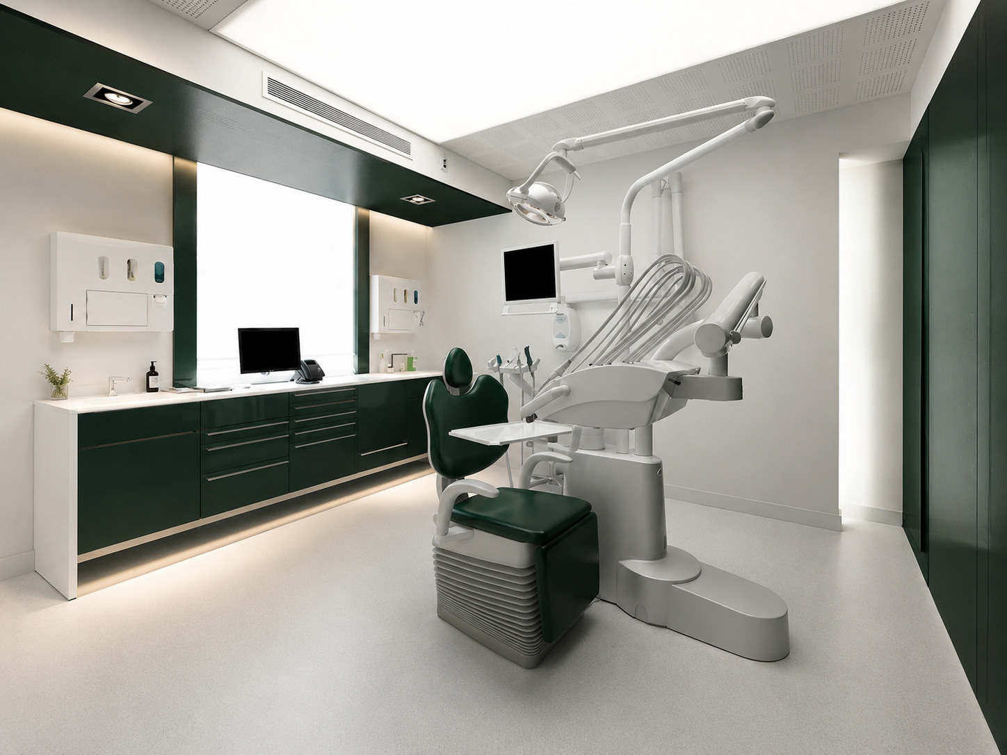 Salle de soins avec fauteuil dentaire et mobilier vert foncé