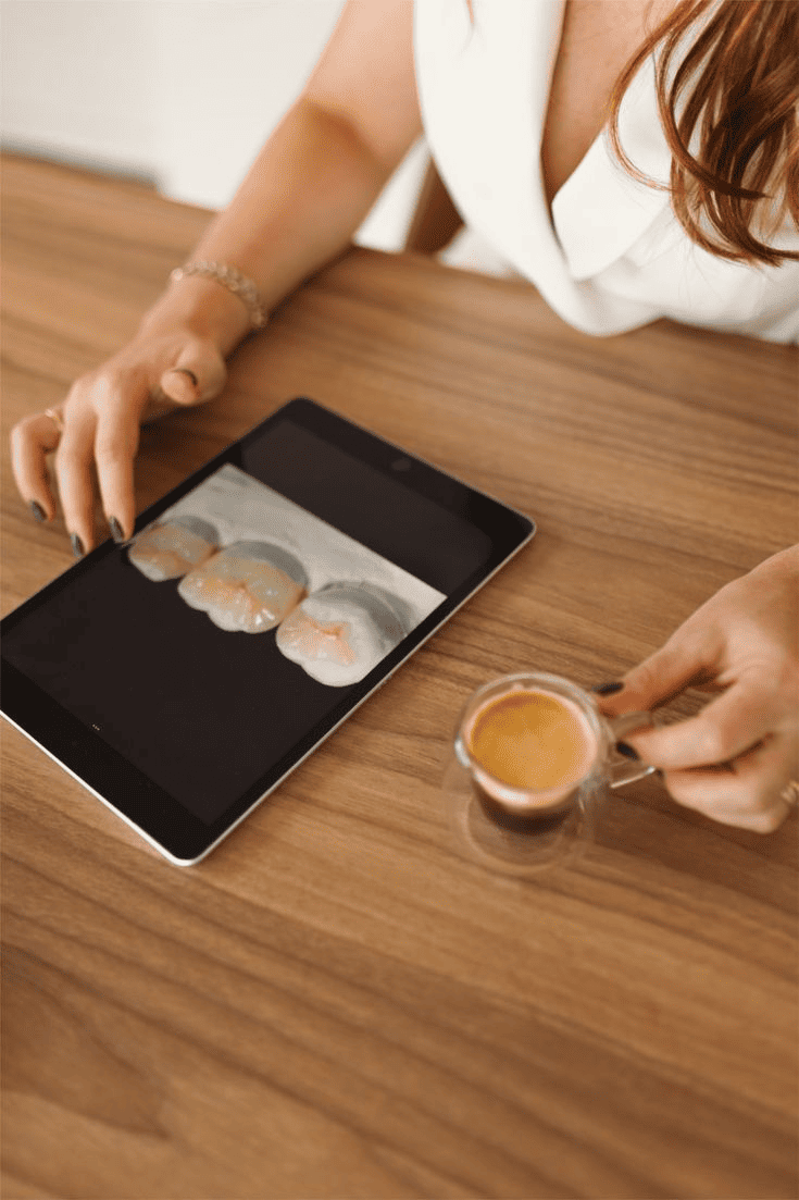 Tablette affichant une image dentaire, posée sur une table en bois