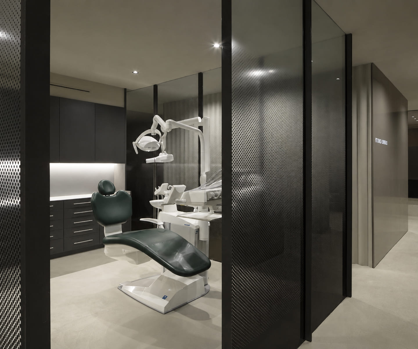 Salle de soins vue à travers des parois vitrées sombres